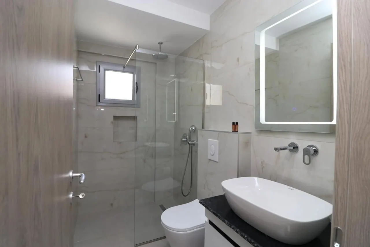 Bathroom with a freestanding tub and a marble surround